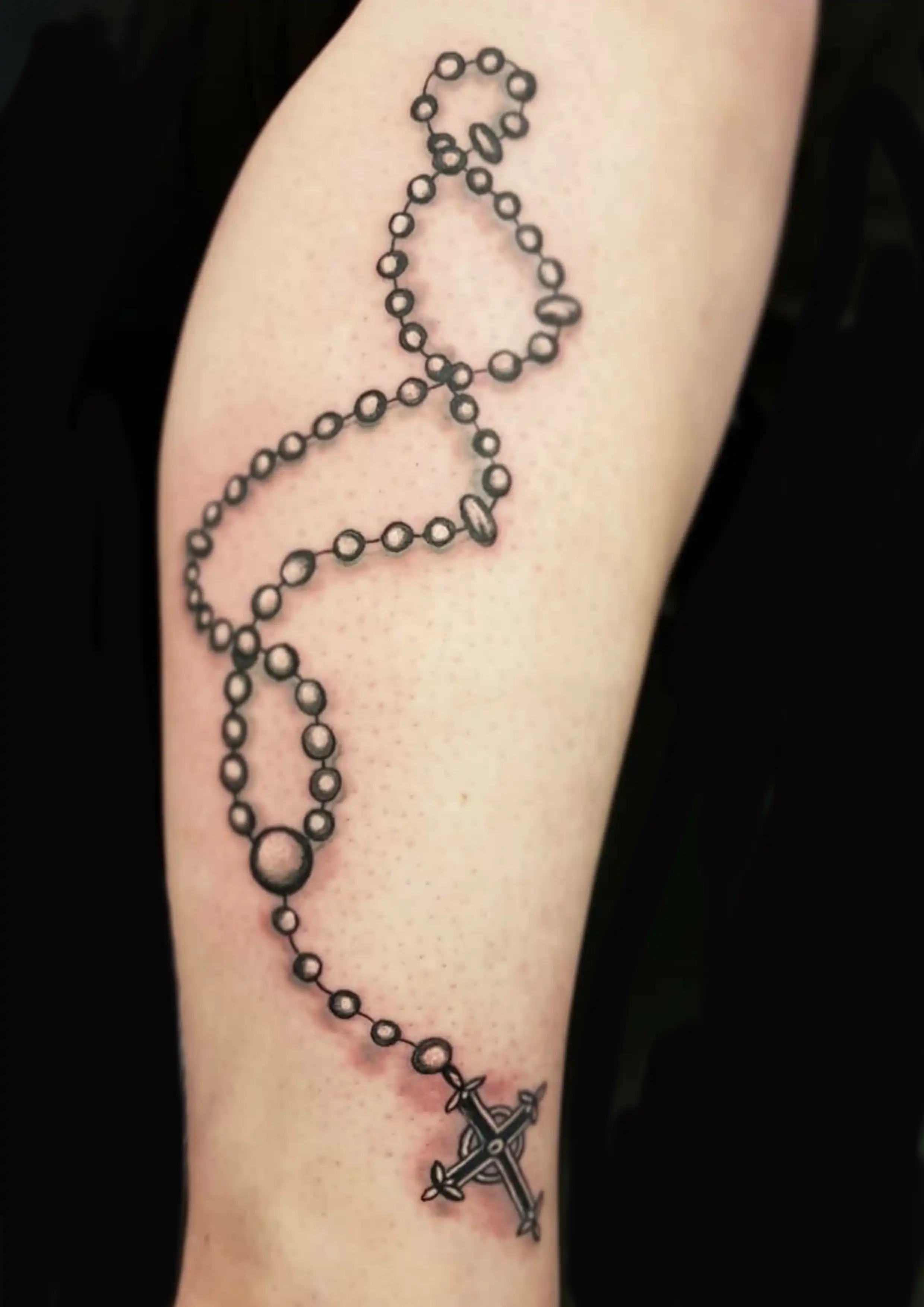 Tattoo von Rosenkranz auf Unterschenkel