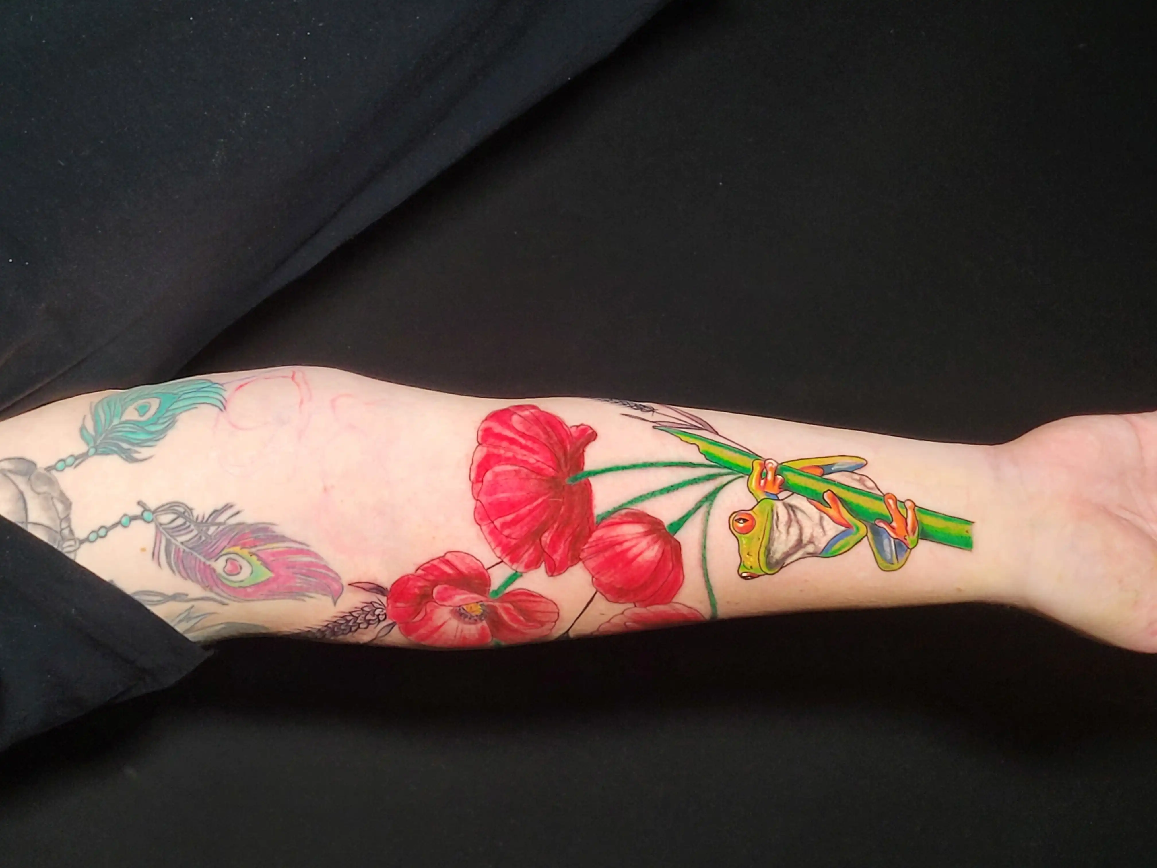 Tattoo von einer Mohnblume mit Frosch farbig