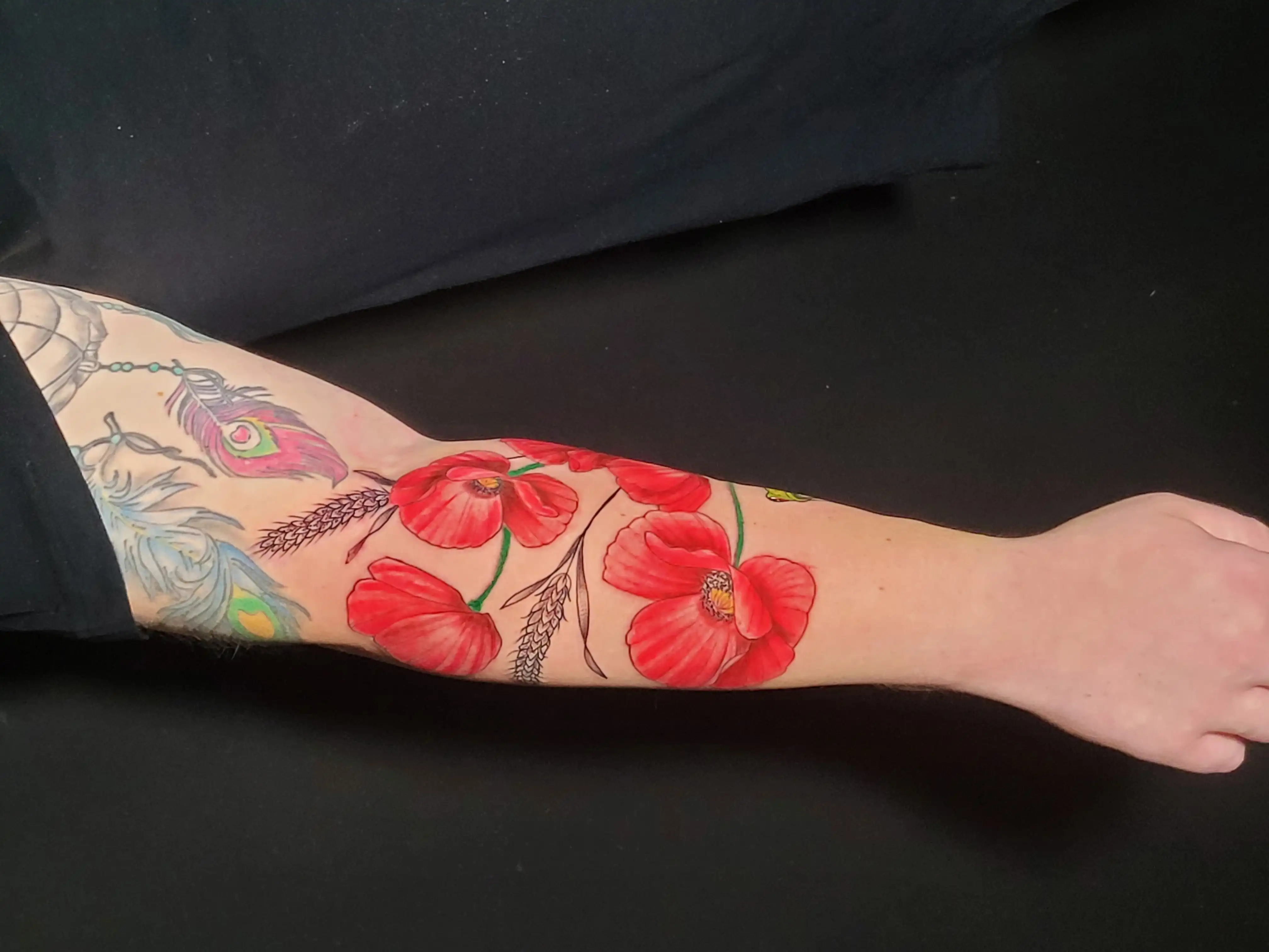 Tattoo von Mohnblume mit Frosch auf Unterwarm